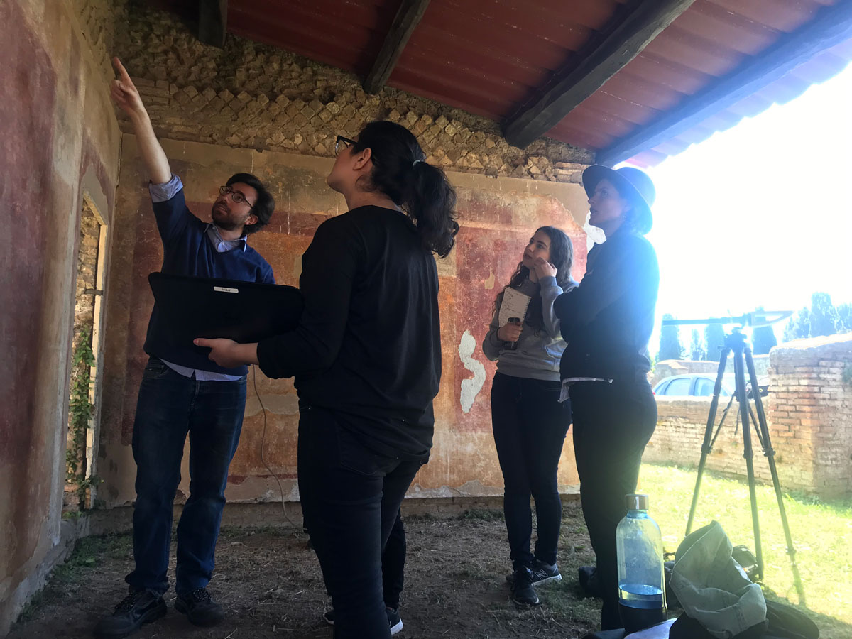 four researchers stand around an ancient wall