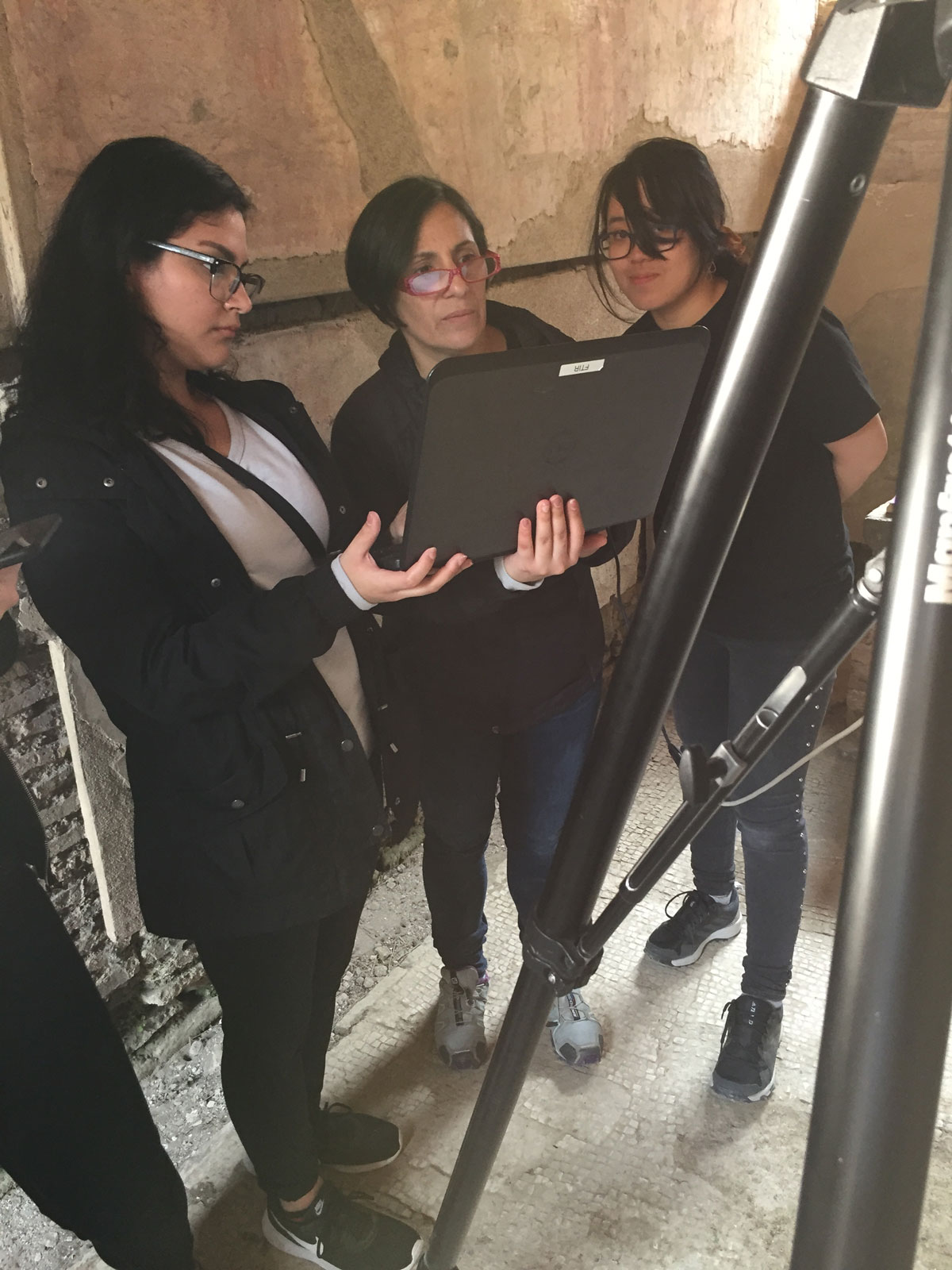 three researchers stand next to each other to discuss research findings