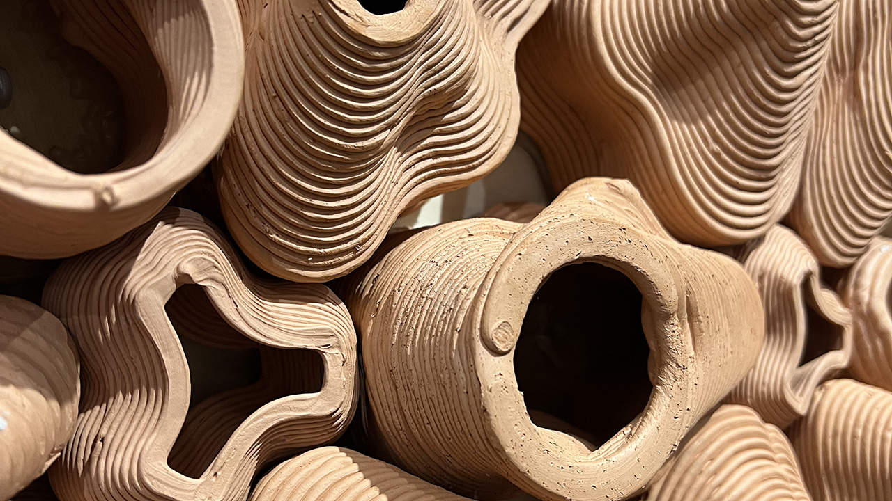 close up view of a collection of cylindrical bricks, hollow in the center for vegetation growth.