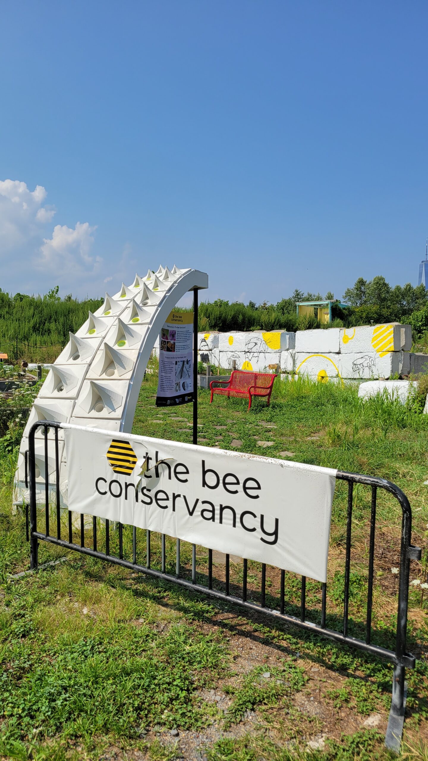 Sign that says The Bee Conservancy in front of an installation of the Pollinators Pavilion