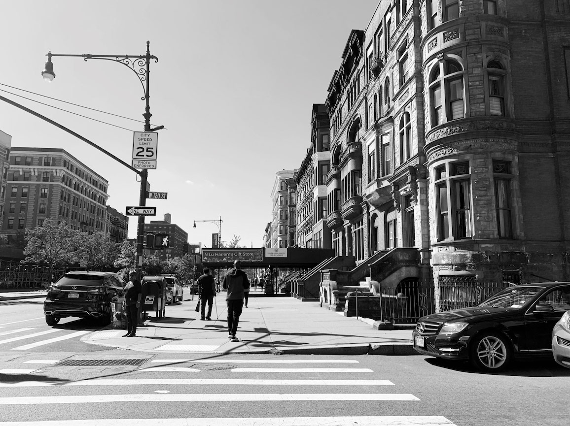 black and white image of crosswalk on a city street corner