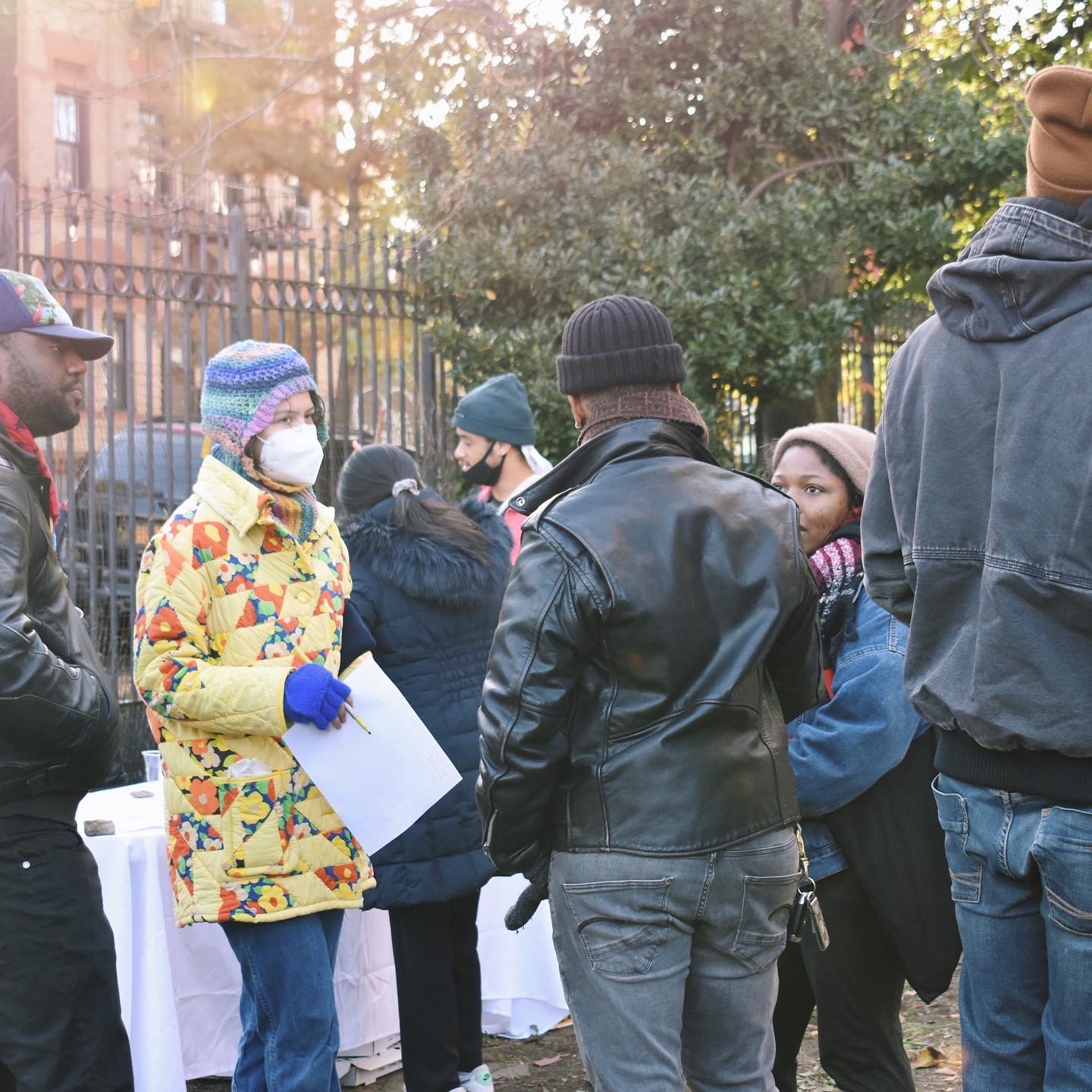 people gathering together and talking at the community garden