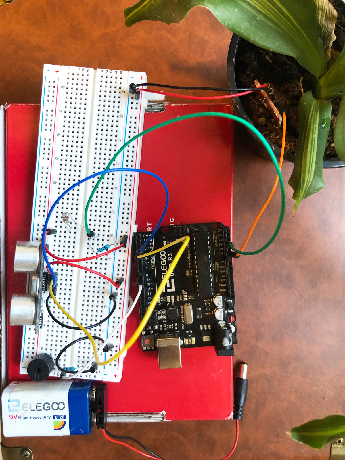 Plant pot and sensors connected to the prototype circuit board, battery, and speaker