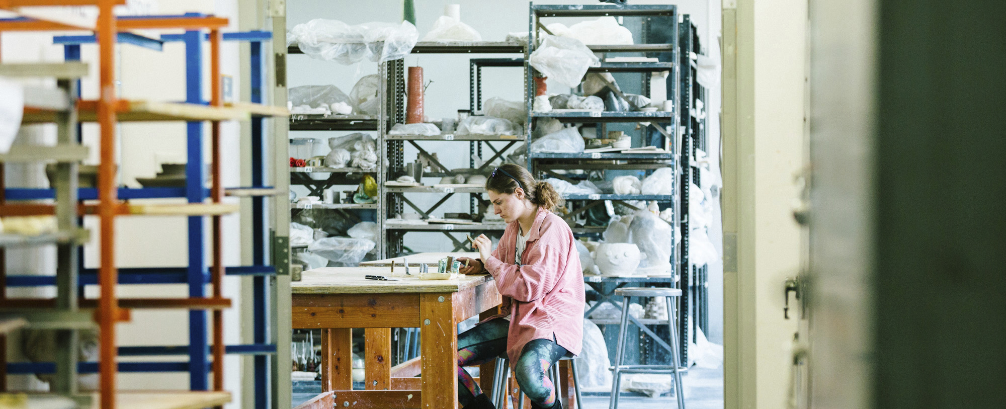 A student works inside a kiln studio.