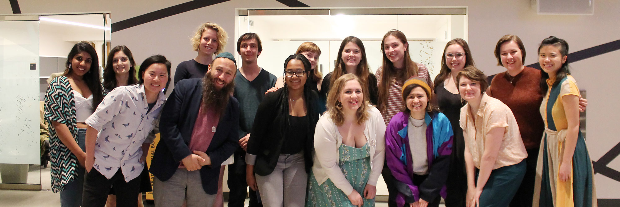 a group of students stand in two rows smiling at the camera
