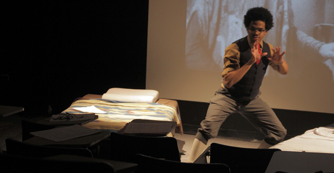 A student rehearses a presentation with a projection in the background.