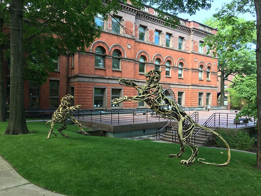 Wendy Klmeperer's Lions at the Gate. The pervading imagery of Klemperer's work reflects a lifelong fascination with animals. Her large-scale sculptures are often constructed from salvaged industrial refuse ravaged by demolition, transformed to contain energy and new life. The welding process is reminiscent of a gesture drawing—the skeletal, steel lines contain both presence and absence. The body language of these animals expresses a feeling or state of being, with motion conveying emotion. Lions at the Gate references heraldic lions, from medieval times back to the lion gate of Mycenae.