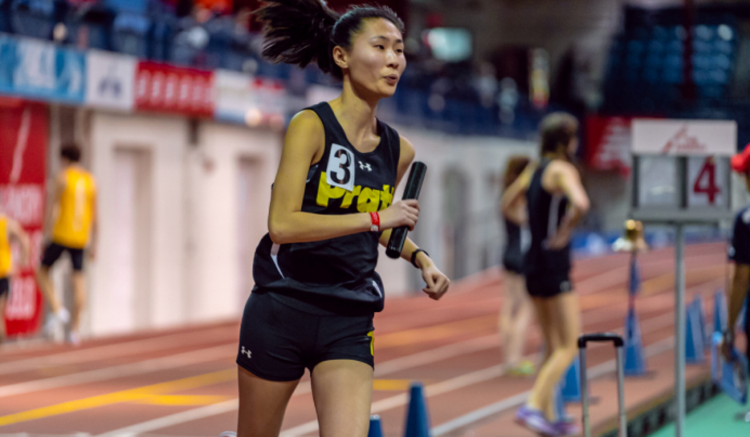 woman running in race, on racetrack, wearing pratt jersey