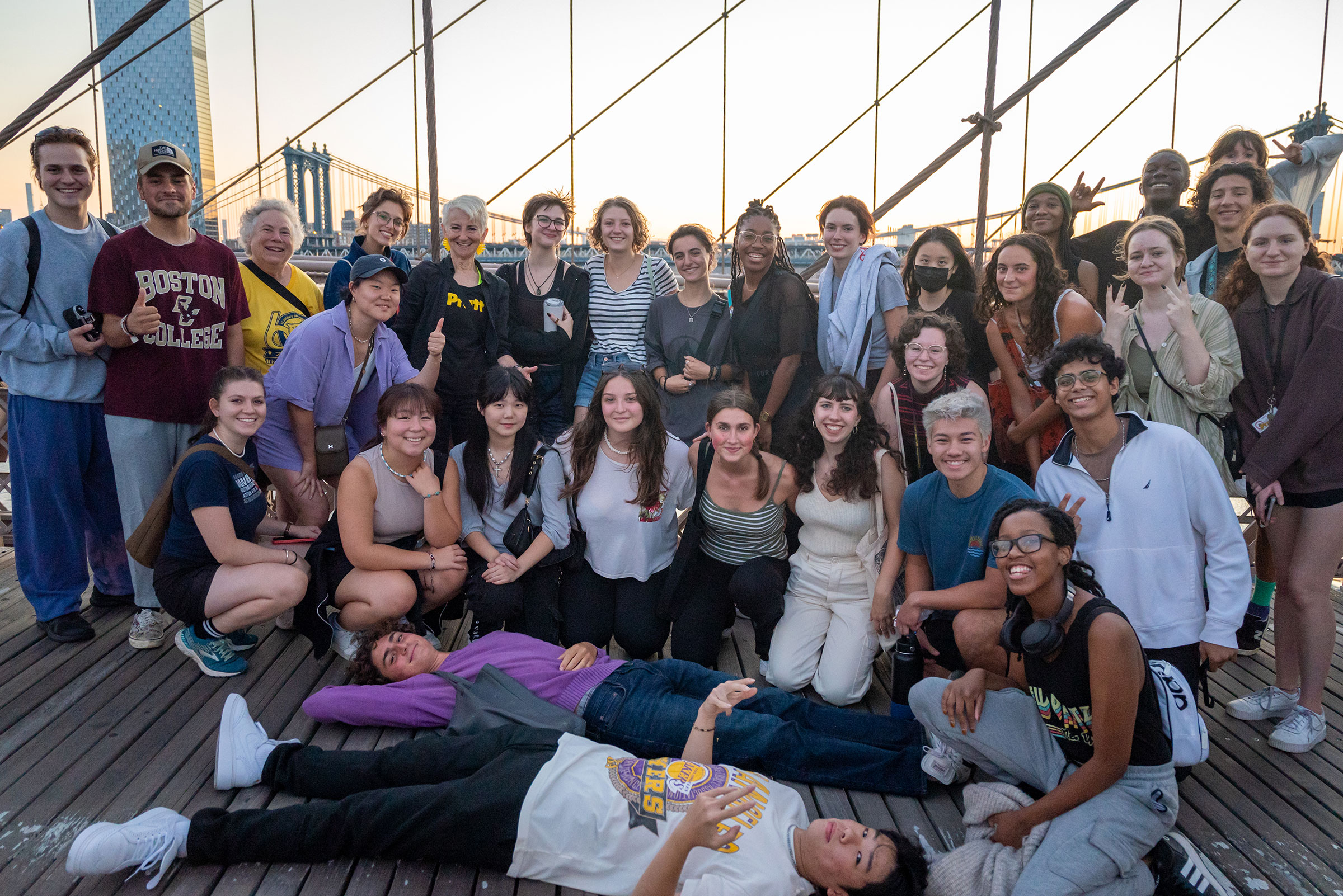 a group of students poses with President Frances Bronet on the Brooklyn Bridge
