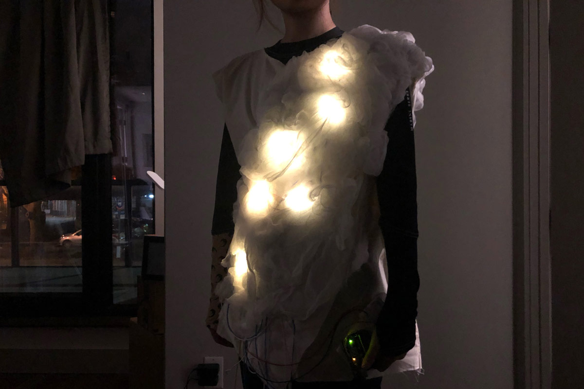 model wears the garment, white lights are on