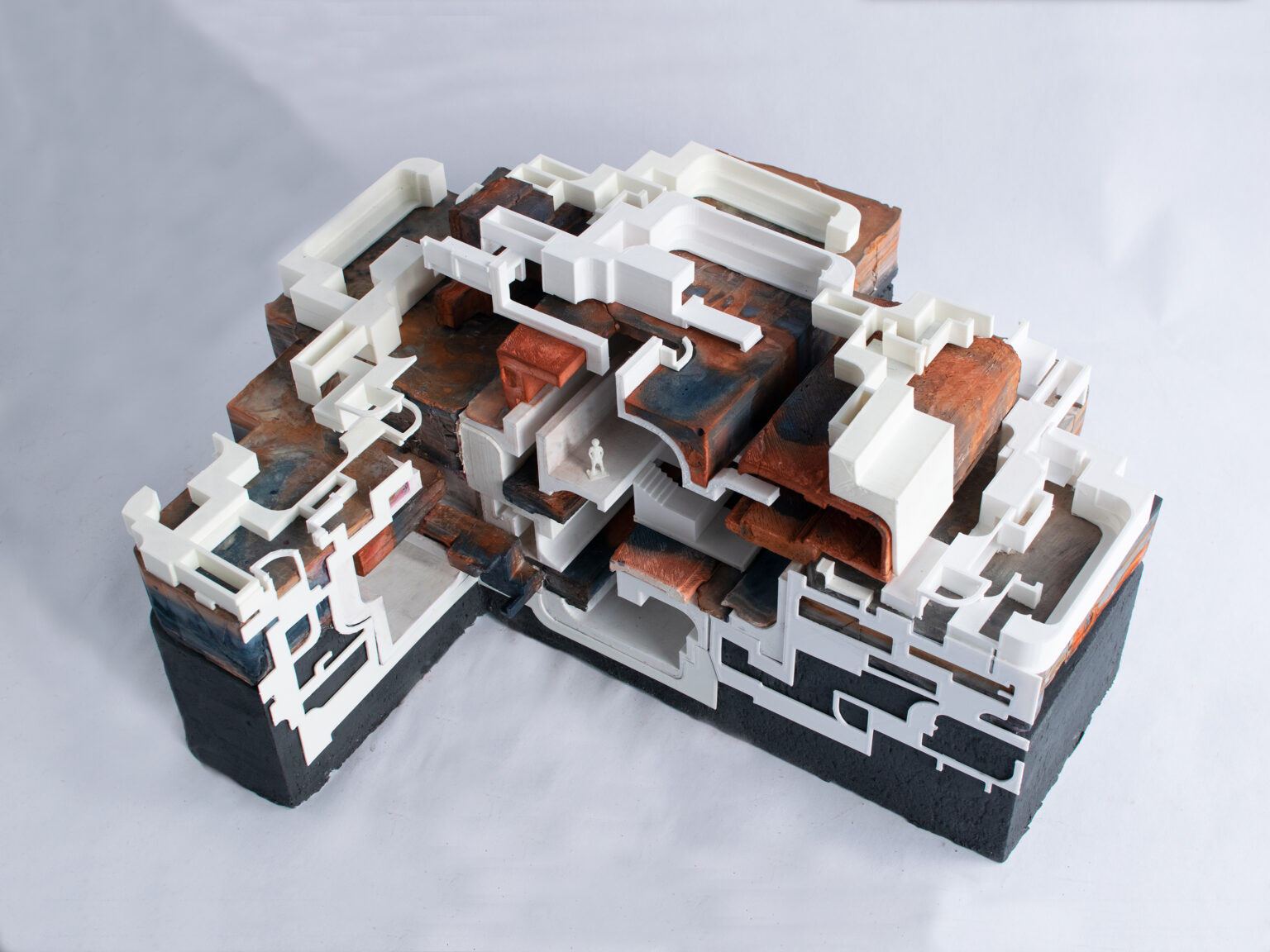 Architectural model of building, with levels in the shape of voxels, white, green, black and red