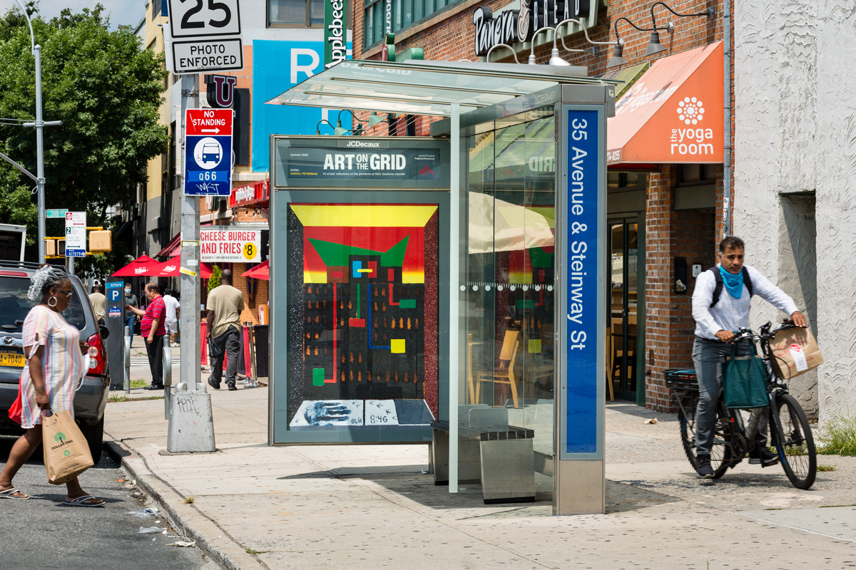 A Queens streetscape with a piece of public art by artist Jamaal Peterman installed in a bus shelter