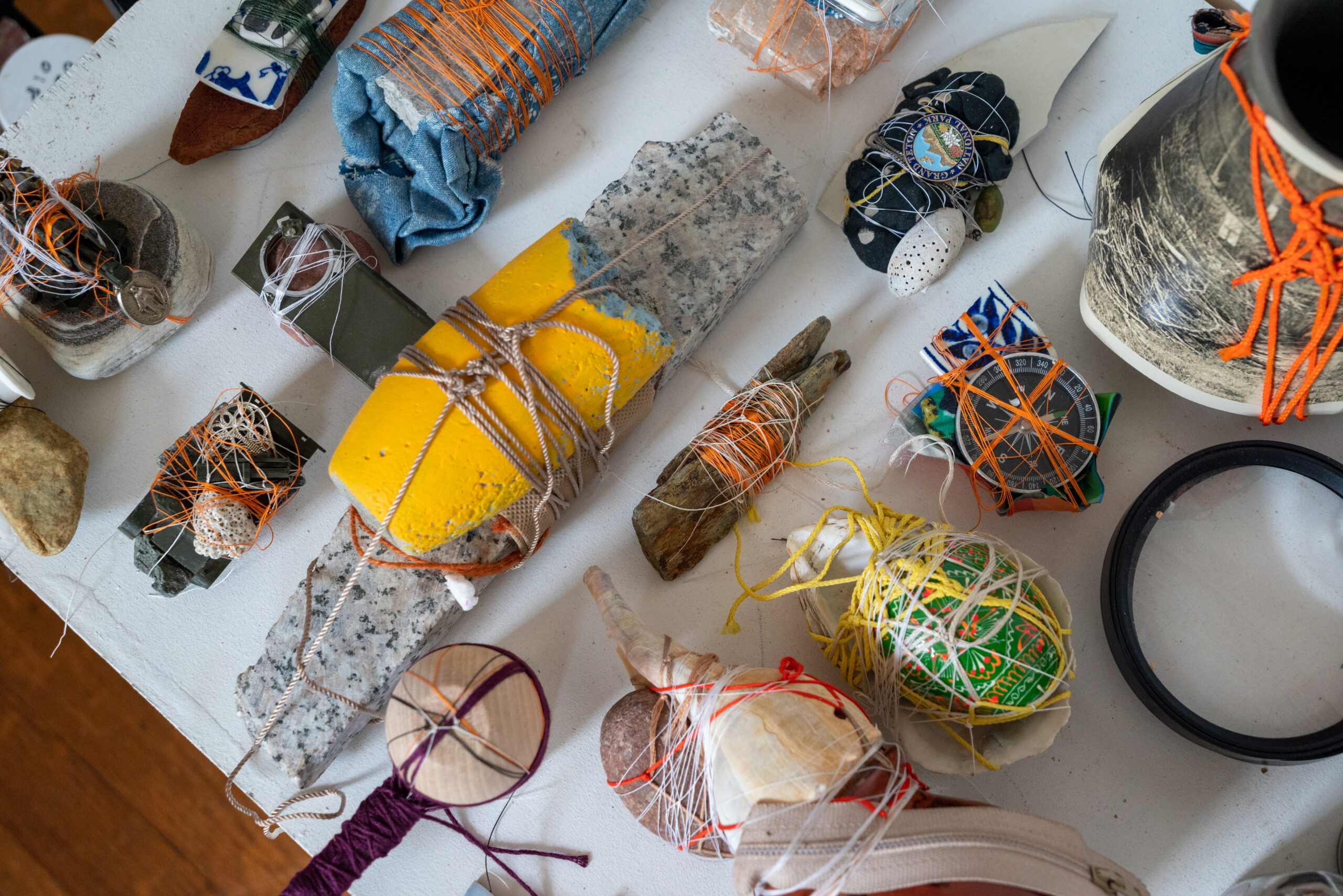 Small items like pieces of wood, shells, stone, and coral fragments are held together in bundles with string and twine
