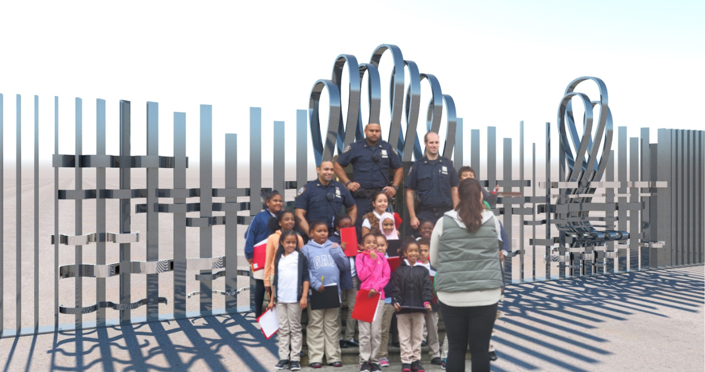 Community residents and police officers pose in front of a woven reflective metal fence