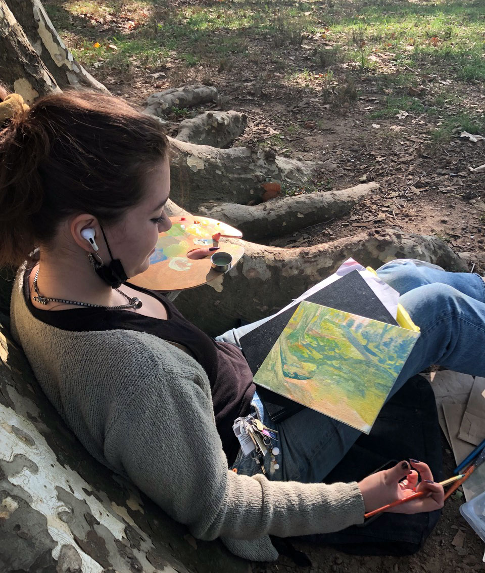 A person sitting on the ground and painting