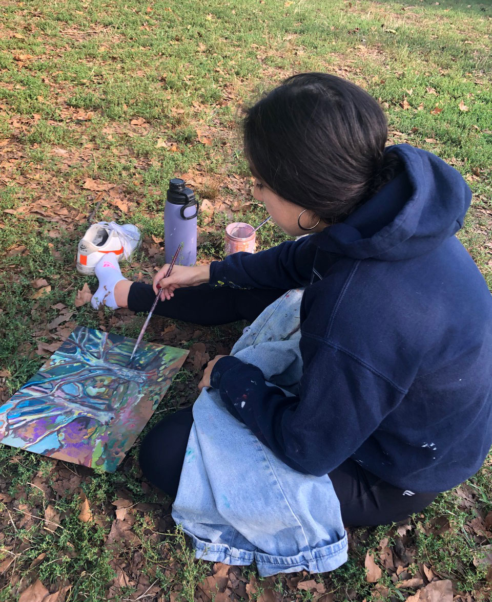 A person sitting on a lawn and painting