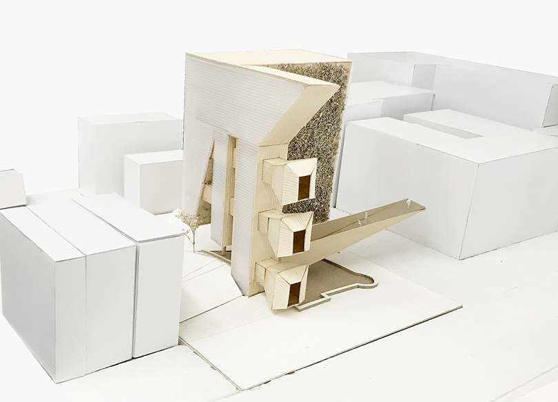 Cardboard model of a building amidst an abstract cityscape.