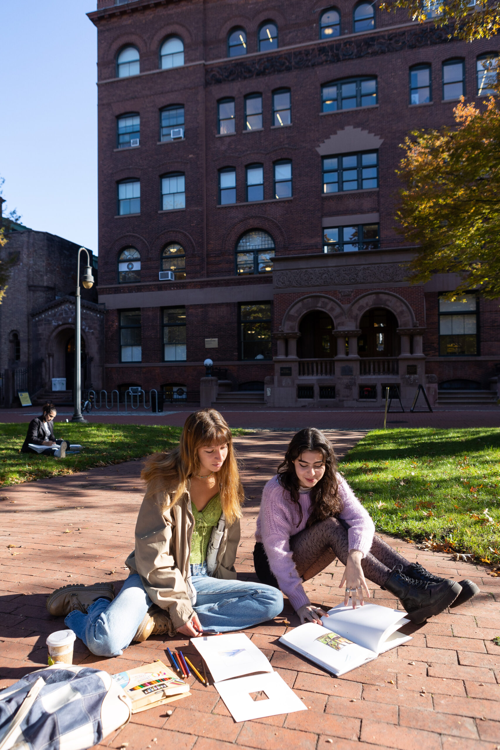 two students seated on campus, going through schoolwork