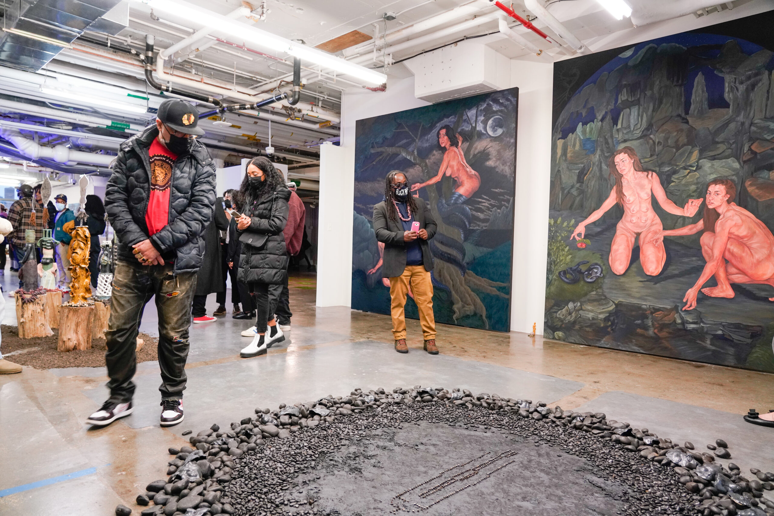 people in gallery, viewing art from students, including sculpture and large-scale painting