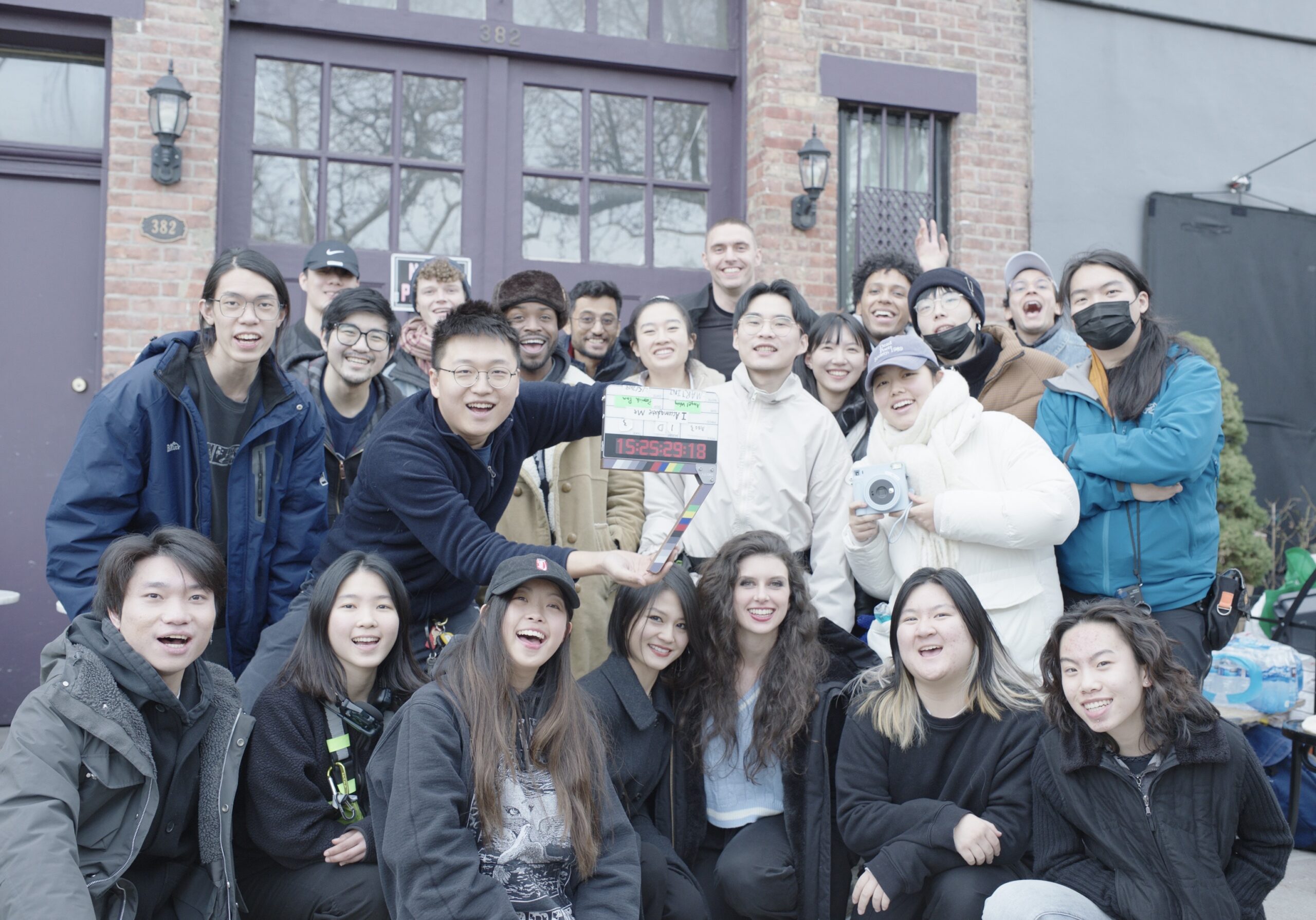 a group of students huddled and smiling for a photo