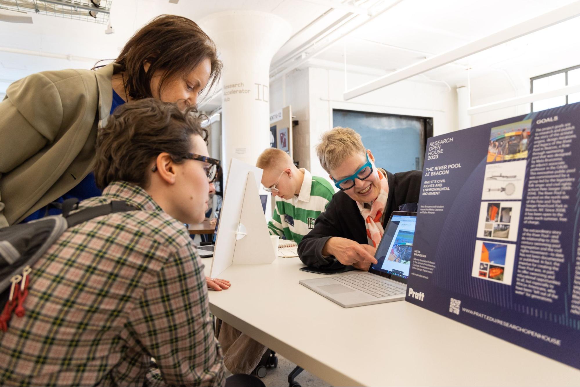 multiple people in a computer lab, working on screens, very happy and enthusiastic about what is being worked on