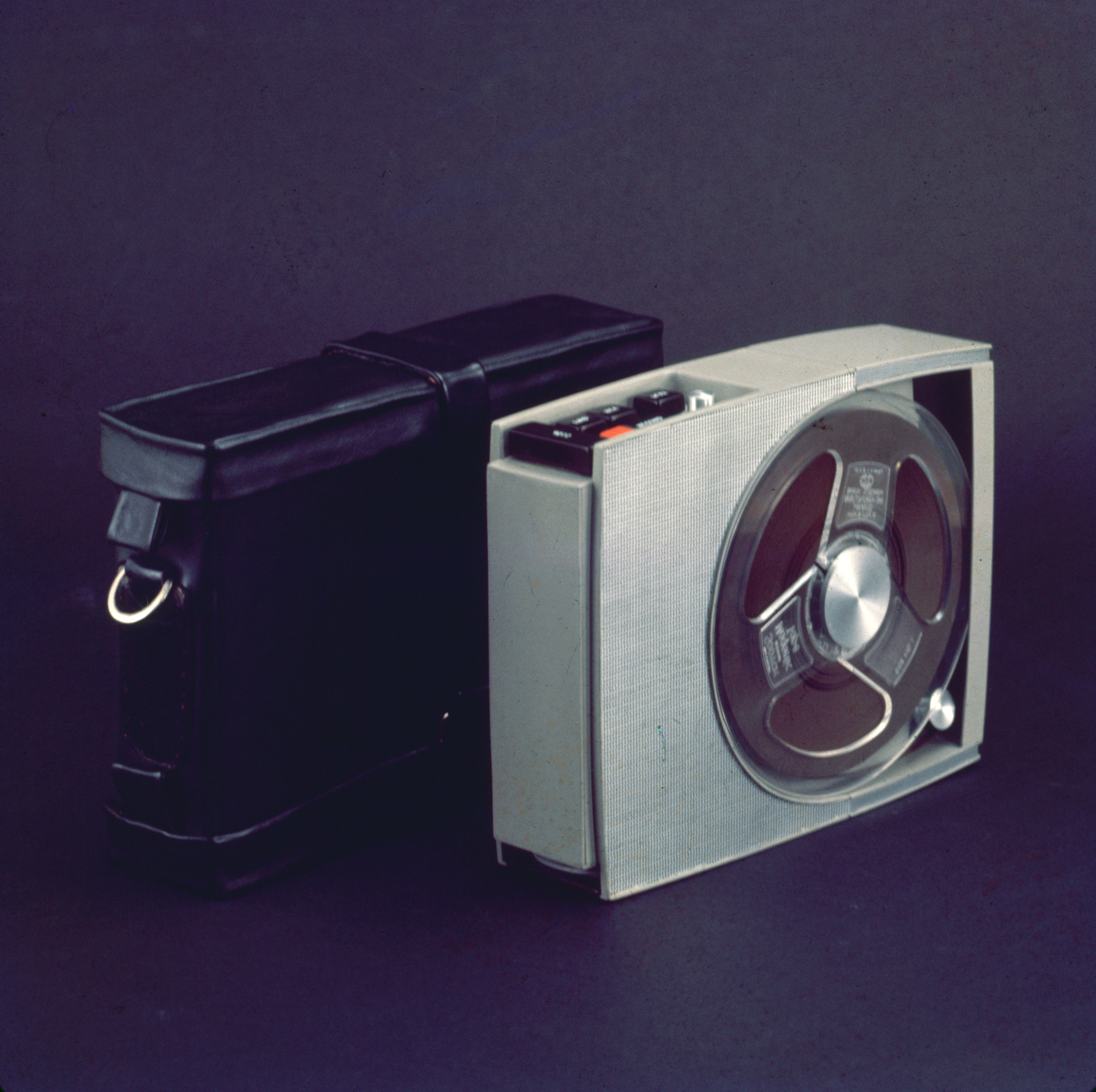 a gray rectangular tape player with a black leather case