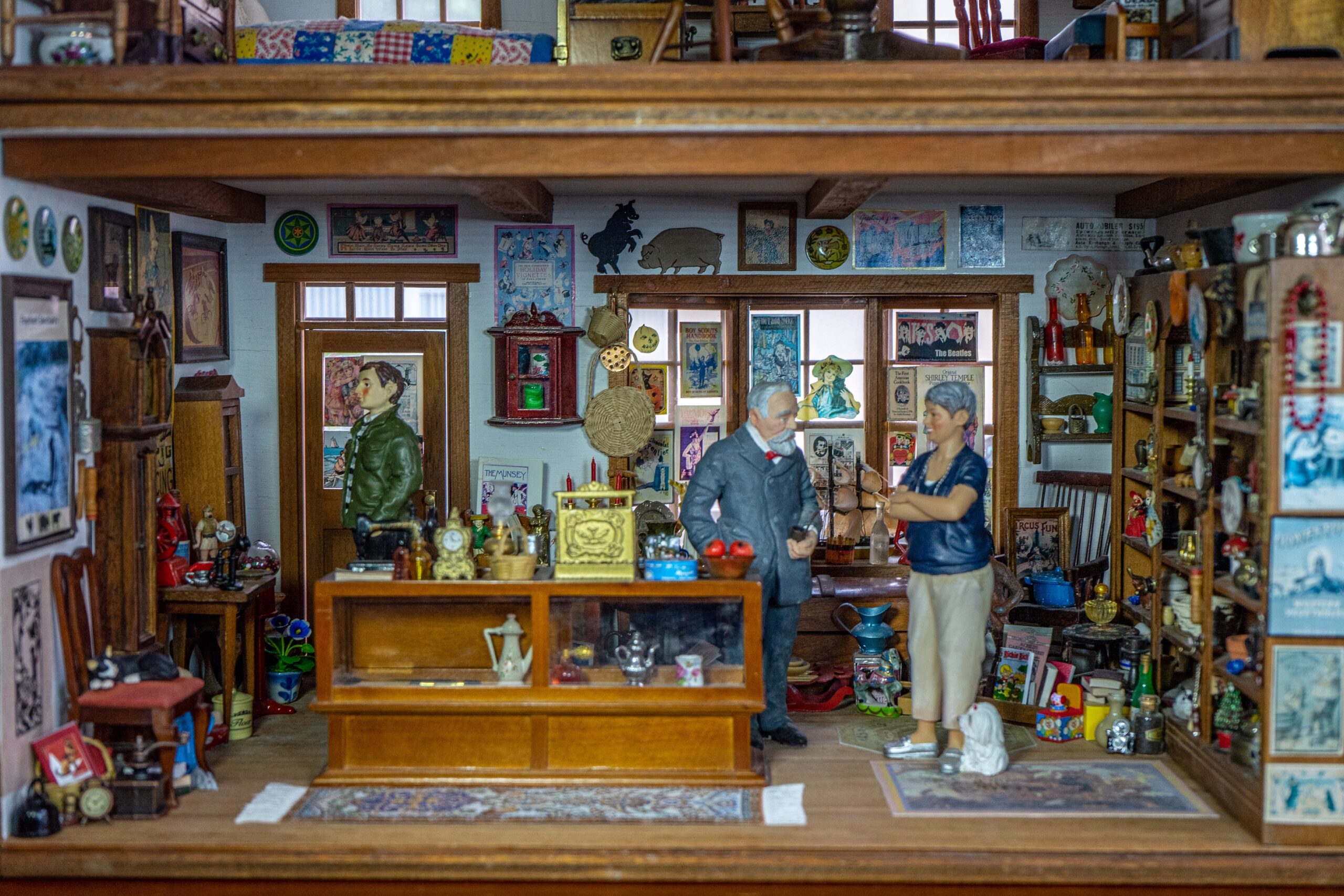 A miniature room stylized like an antique shop, including small figurines and objects like clocks, teapots, and posters.