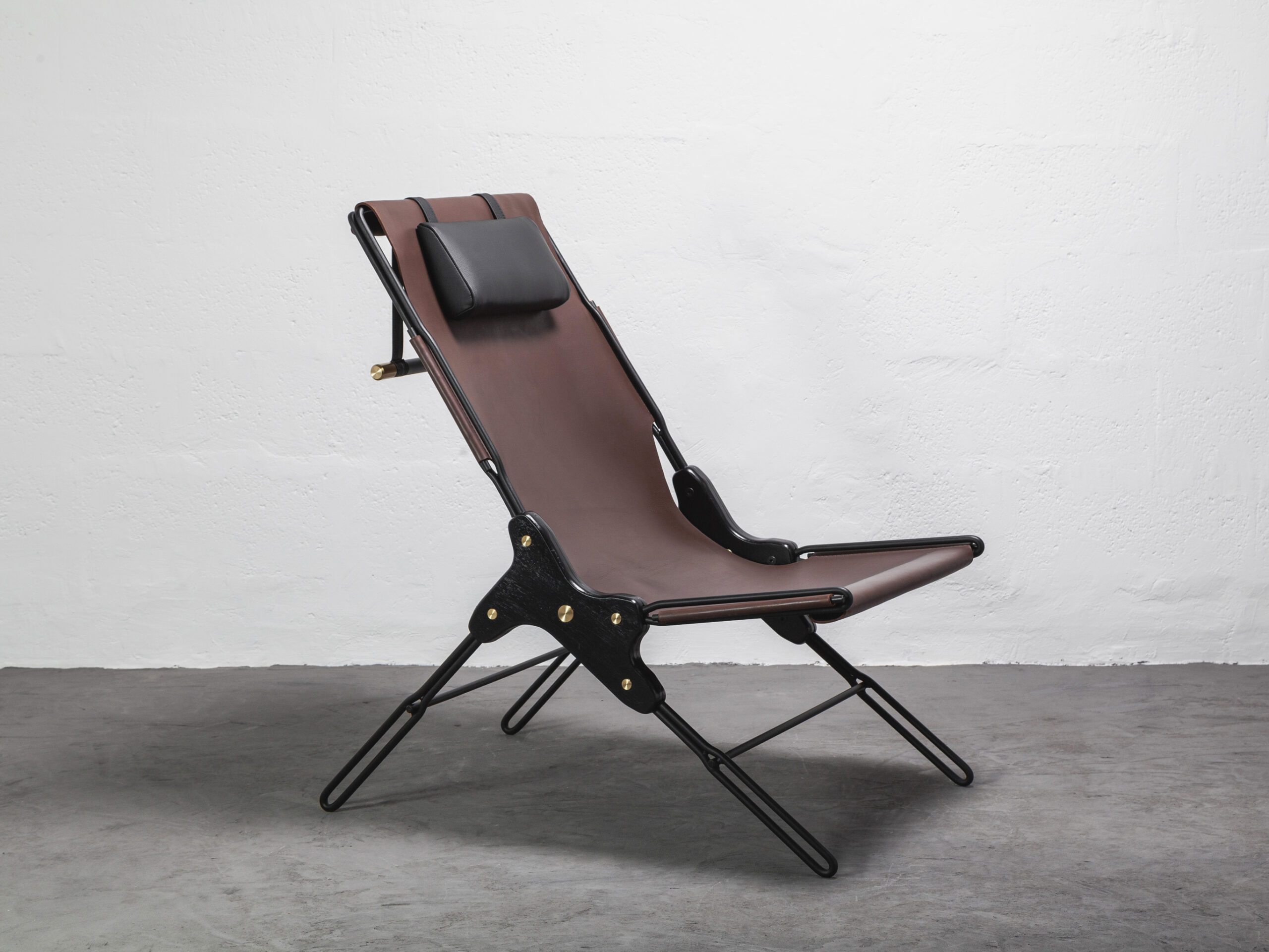 A brown reclinable chair with a head cushion.