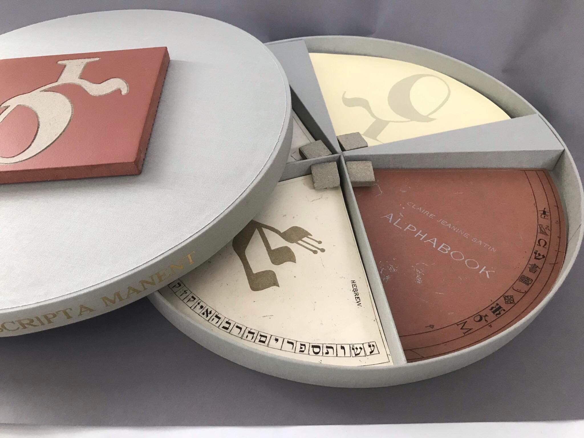 A circular book in four sections, each featuring a unique symbol on the cover.