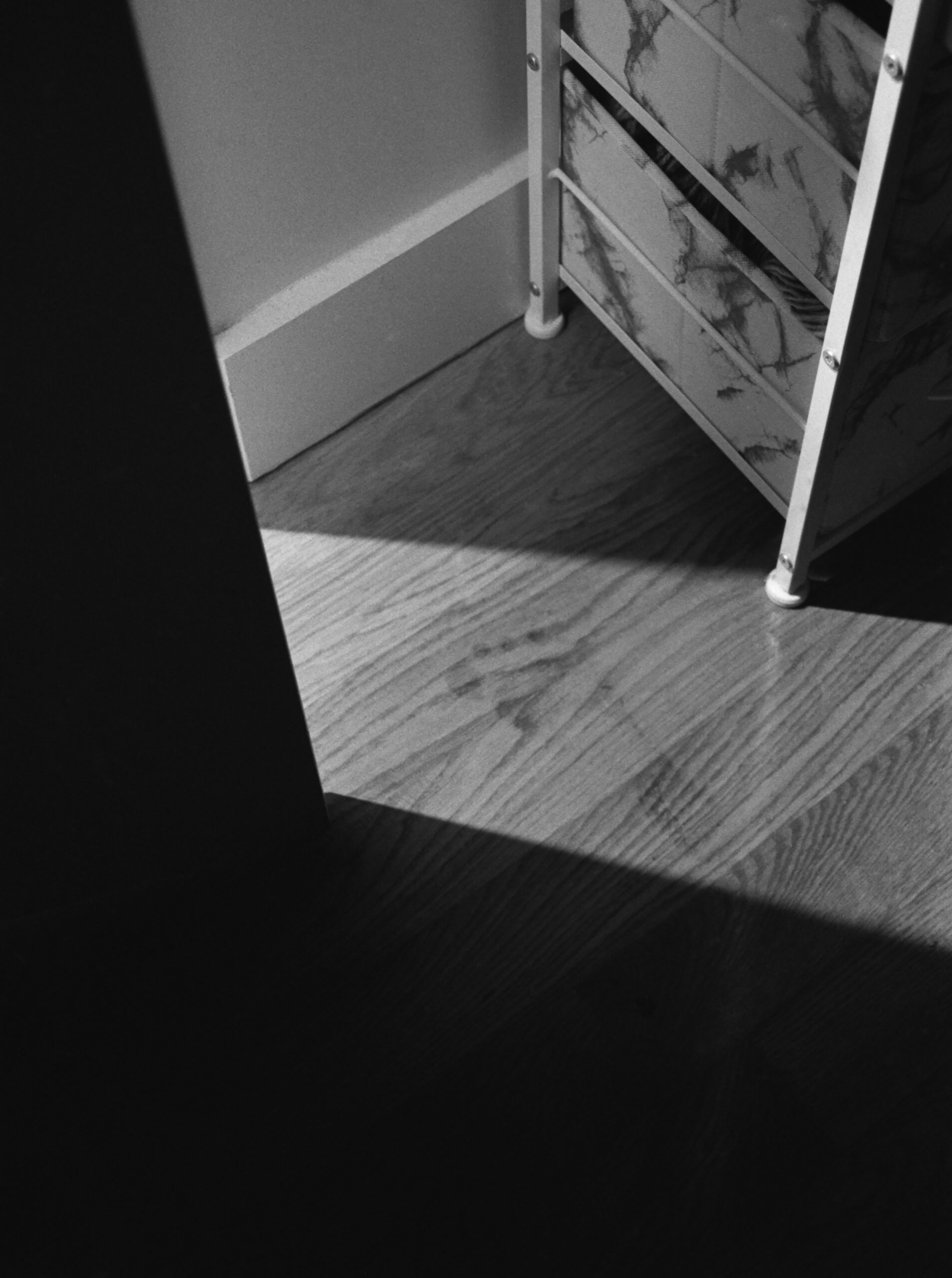 A wet footprint illuminated by a shaft of light on a wood floor