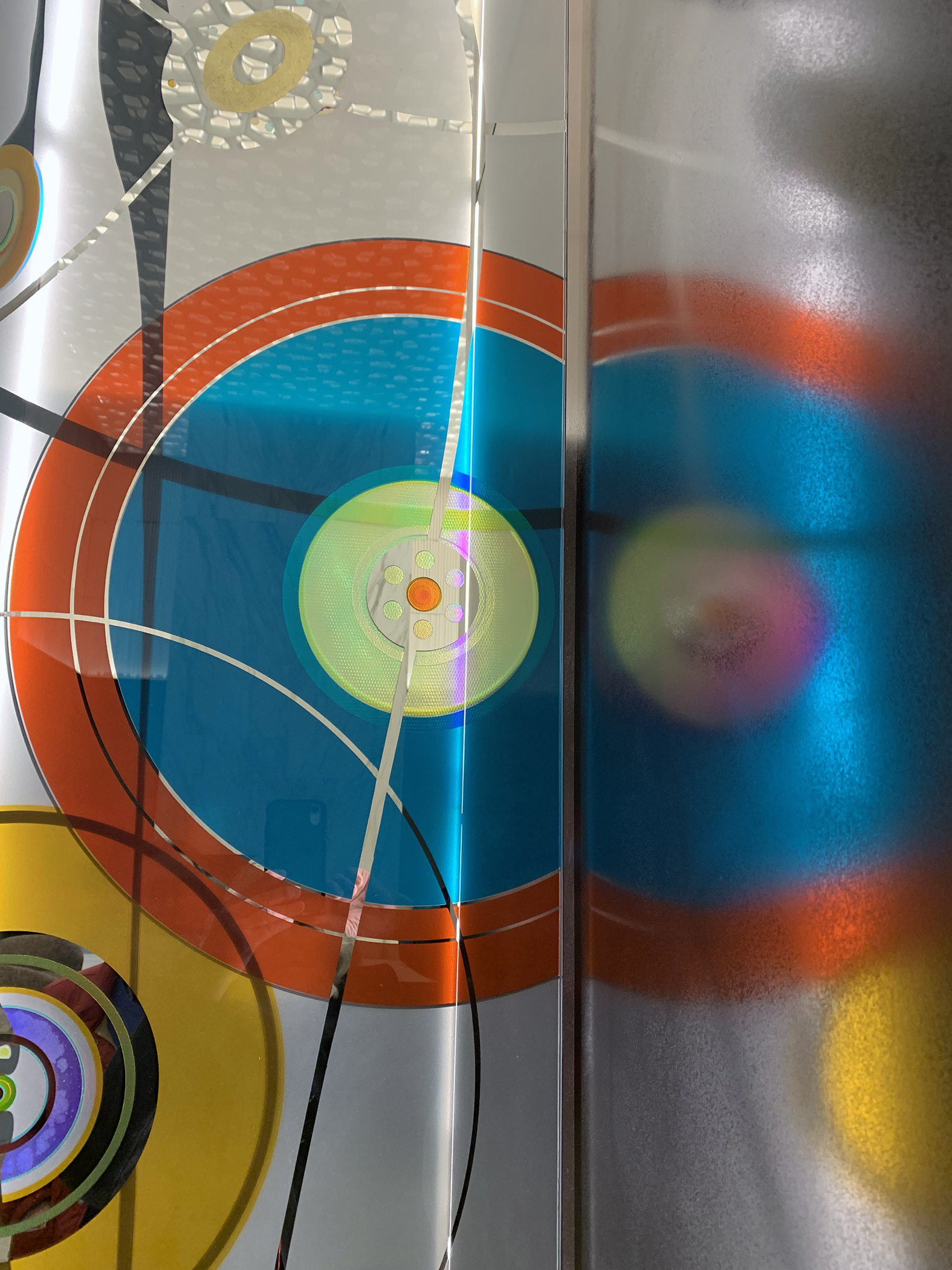 An artwork of colorful circles in glass, in orange, blue, green, and yellow.