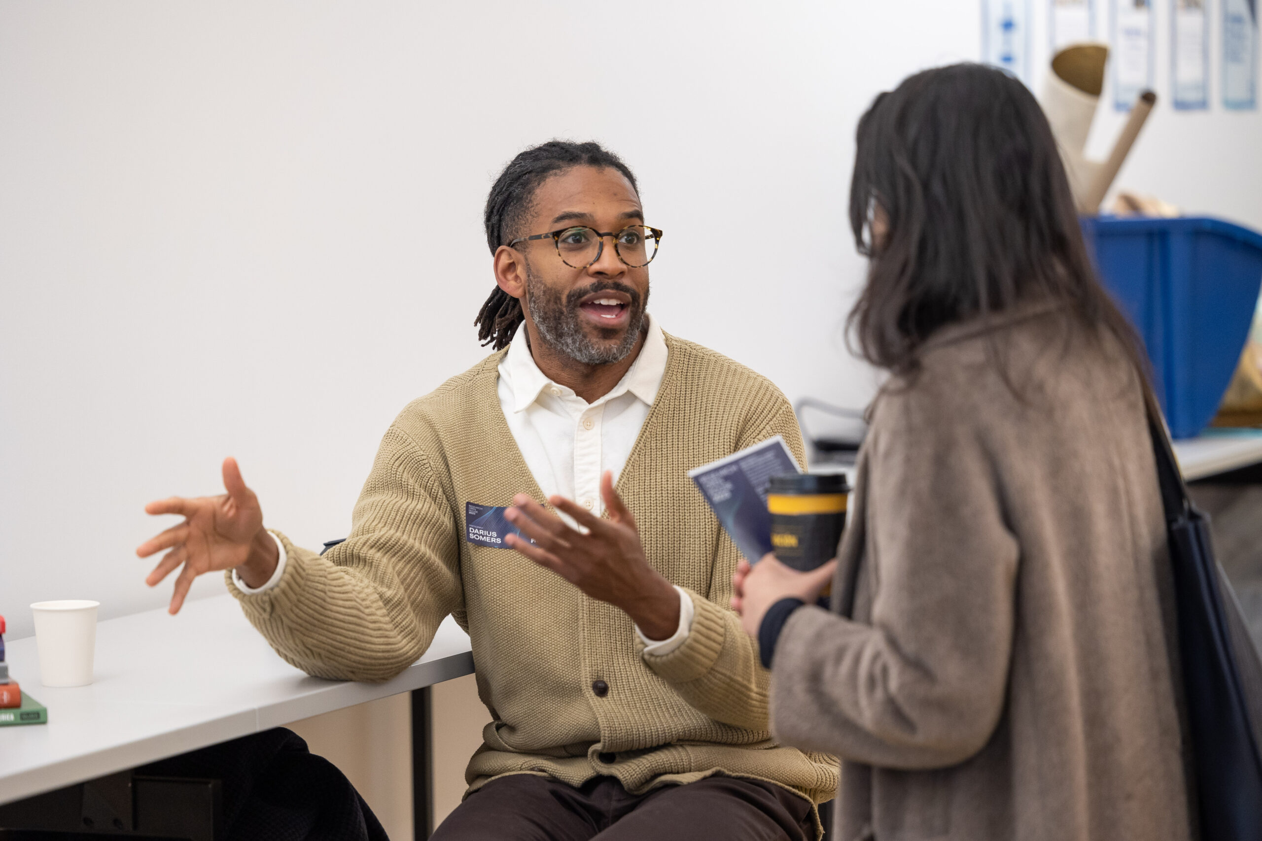 Faculty member and student in animated conversation at Pratt's Research Open House 2023