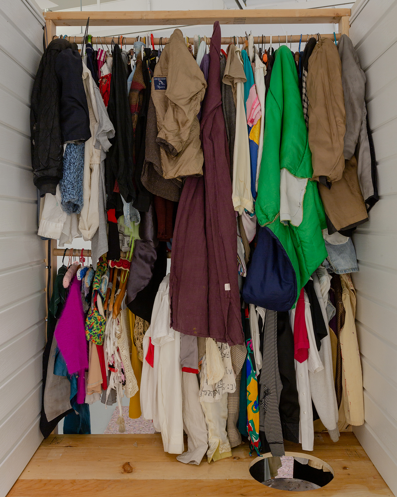 a sculpture by Camilla Carper showing various garments tightly packed inside a messy closet