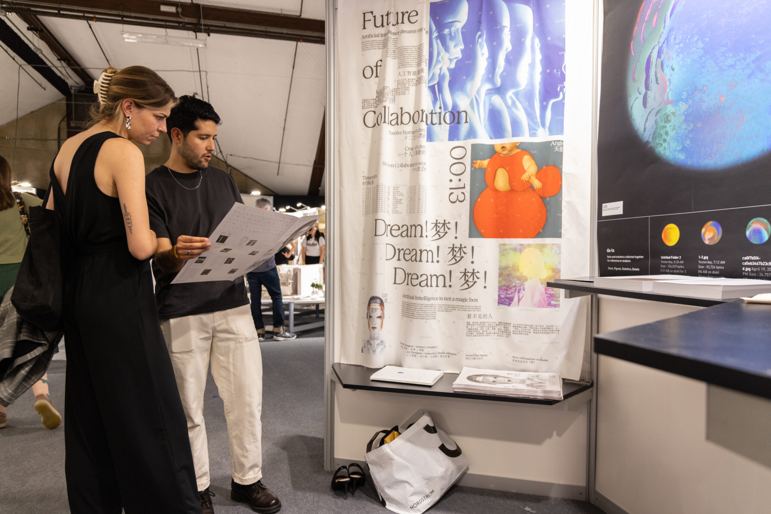 two people going over an installation, checking schematics, and preparing for an opening