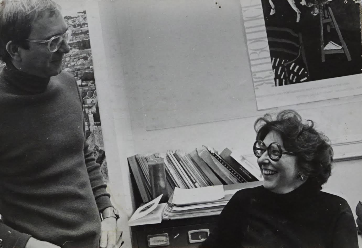 Two people laugh with one another in an office