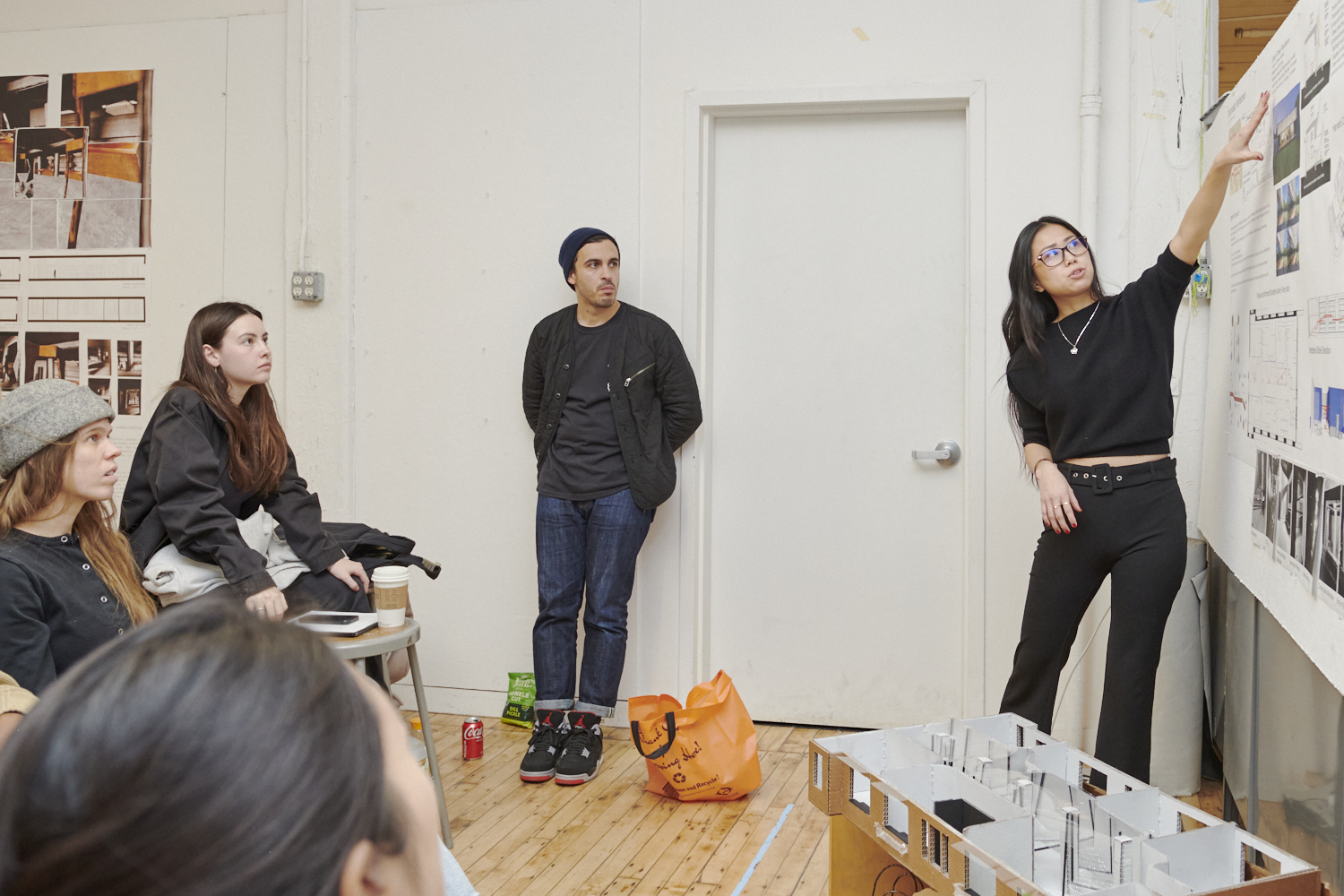 students discussing information on a storyboard, one woman pointing at the storyboard