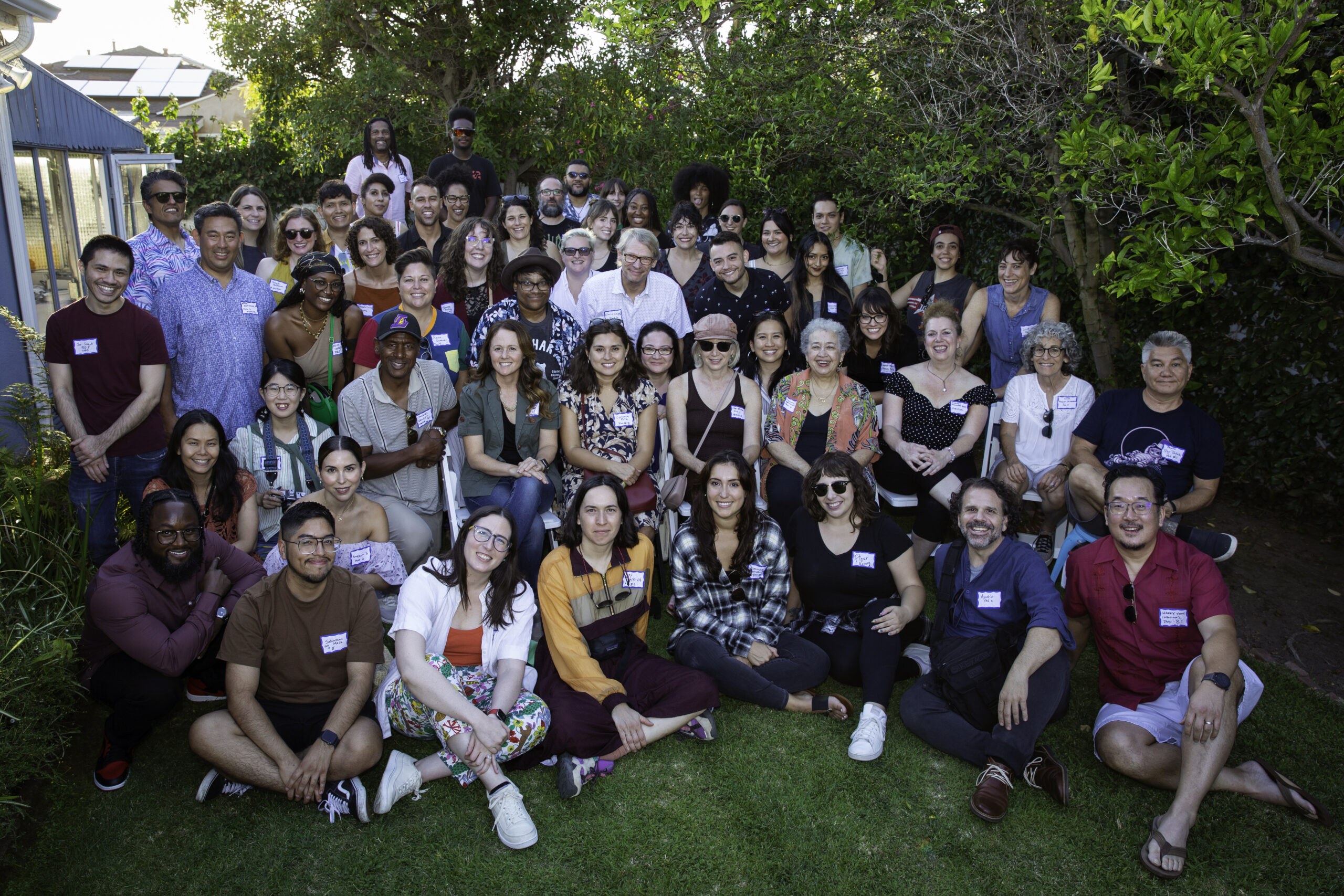 A large group of people standing in a bucolic outdoor setting.