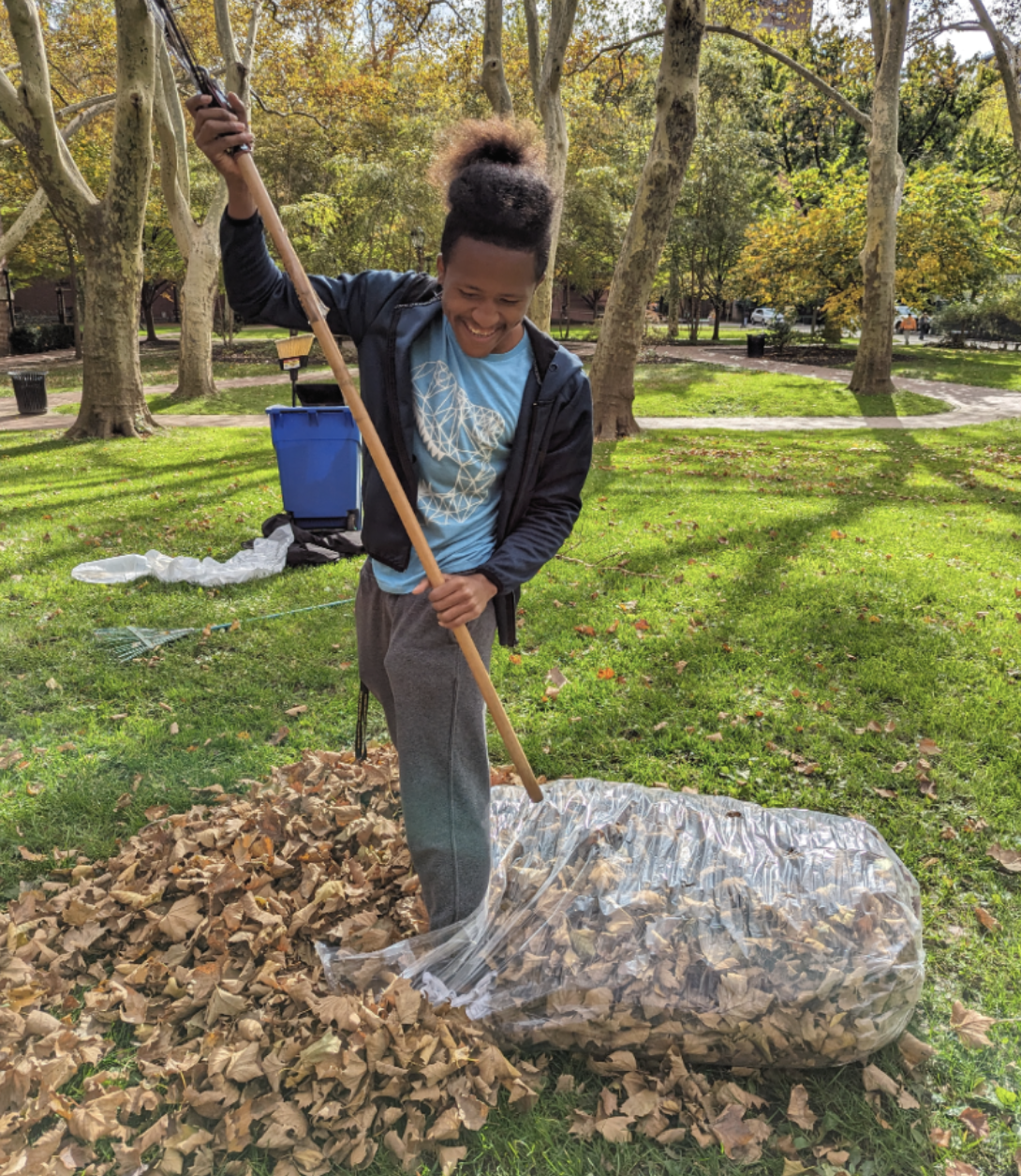 Project SEARCH intern raking leaves on campus