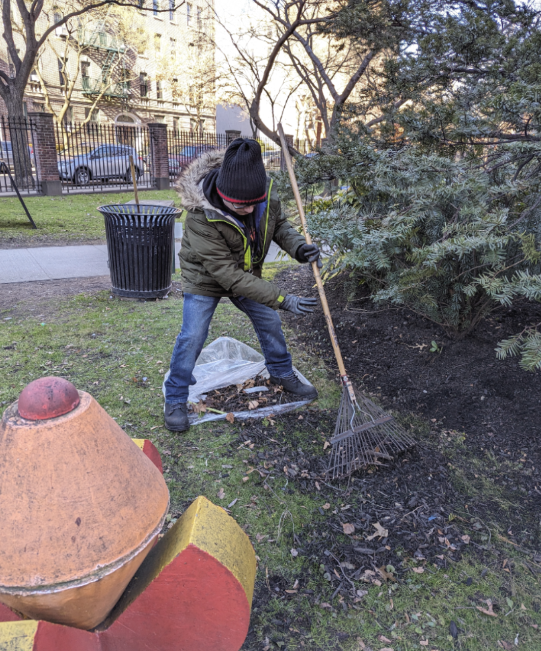 Project SEARCH intern raking leaves on campus