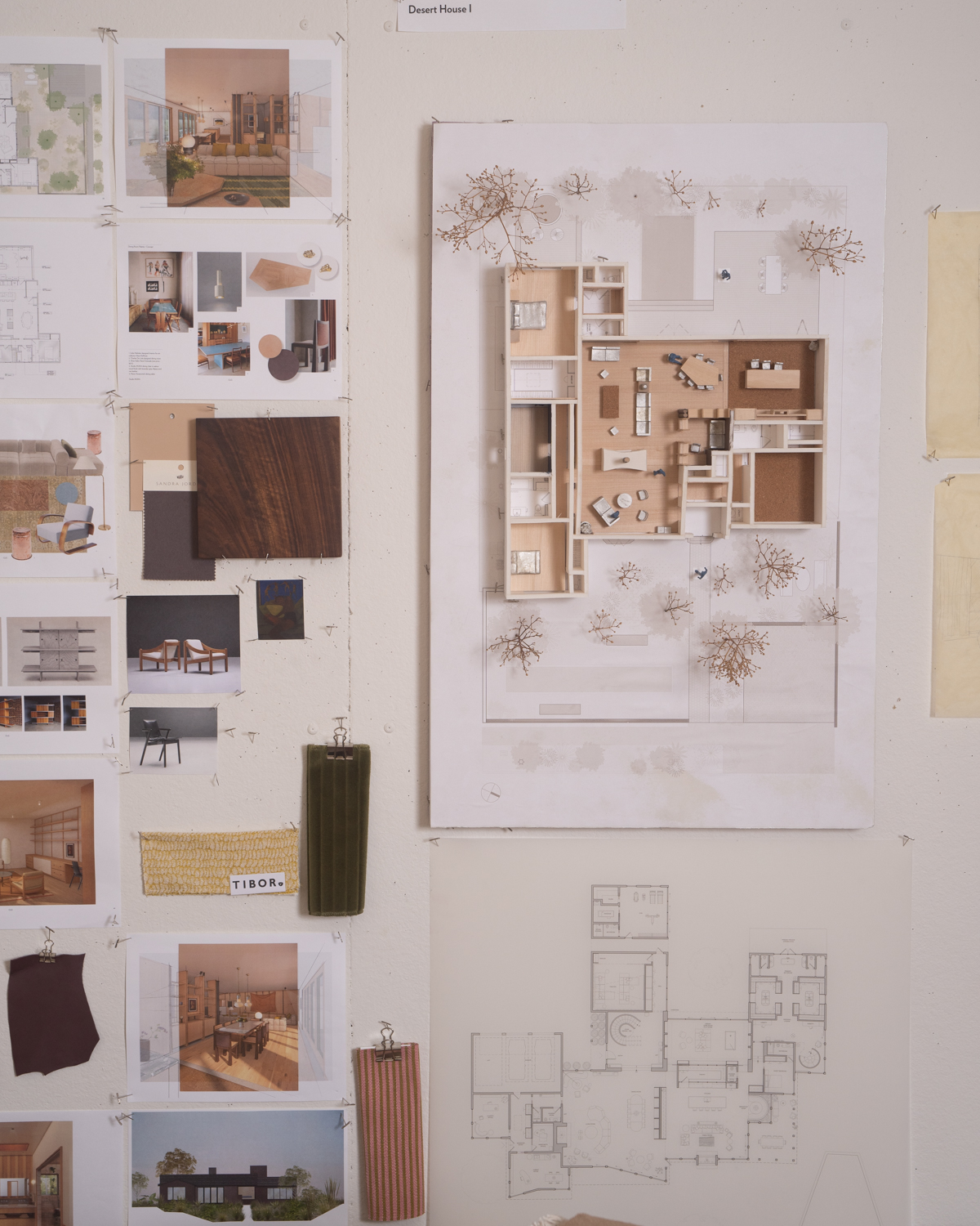 An architecture studio wall pinned with drawings, a 3D model, material samples, and reference photos.