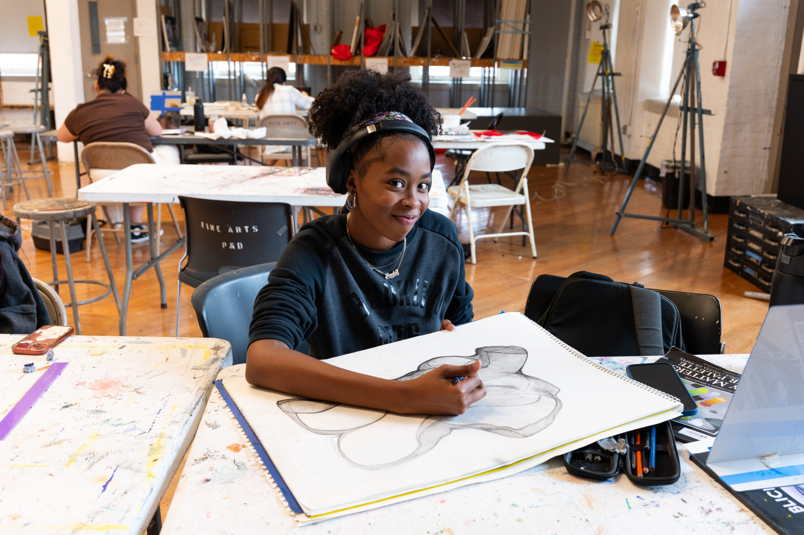 A girl with a sketchbook in an art class