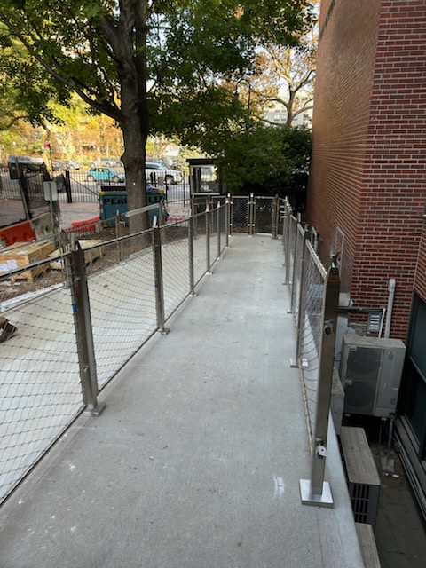 A newly constructed ramp with metal railings, leading to a building entrance.