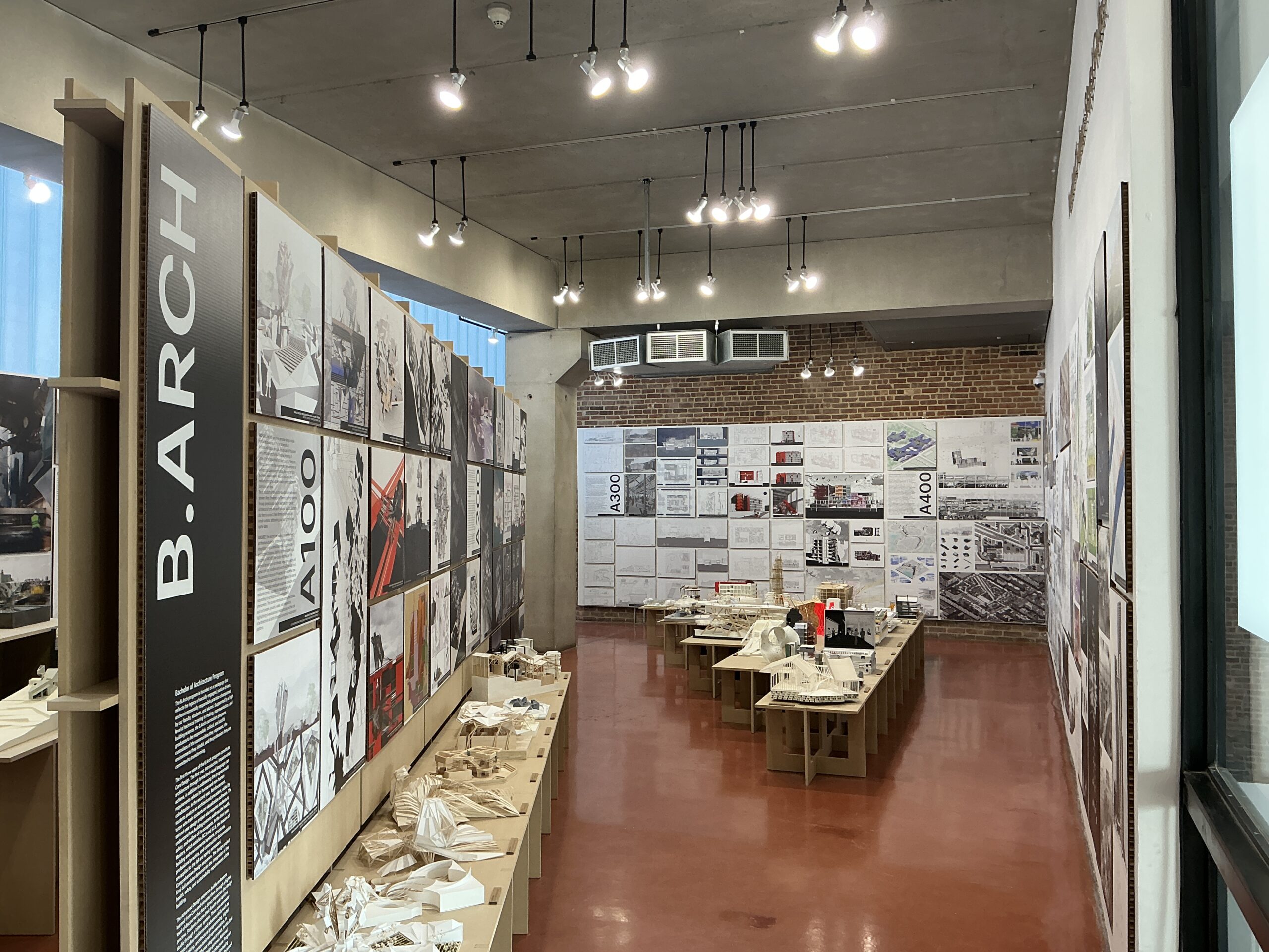 A wider perspective of the architecture exhibit, showing a central display panel labeled 
