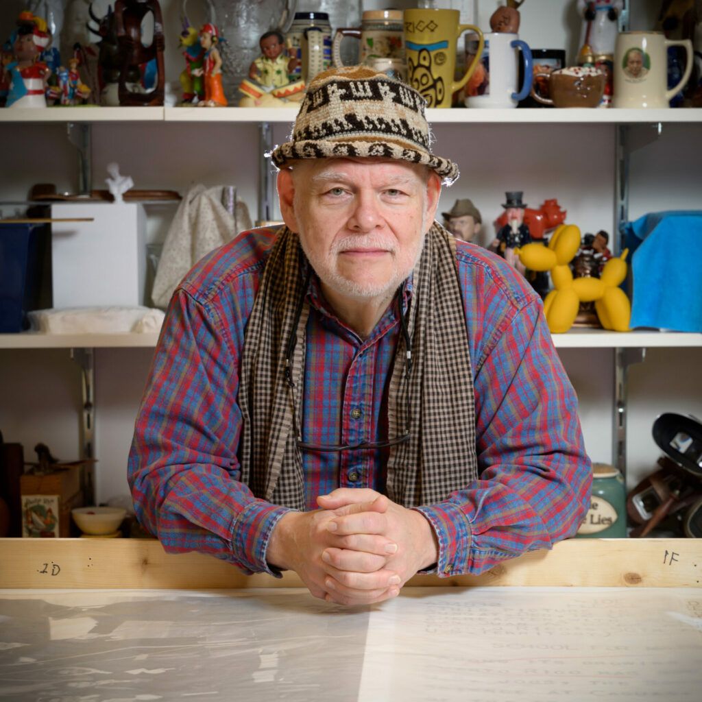 Image of Pablo Delano in front of shelves of his work.