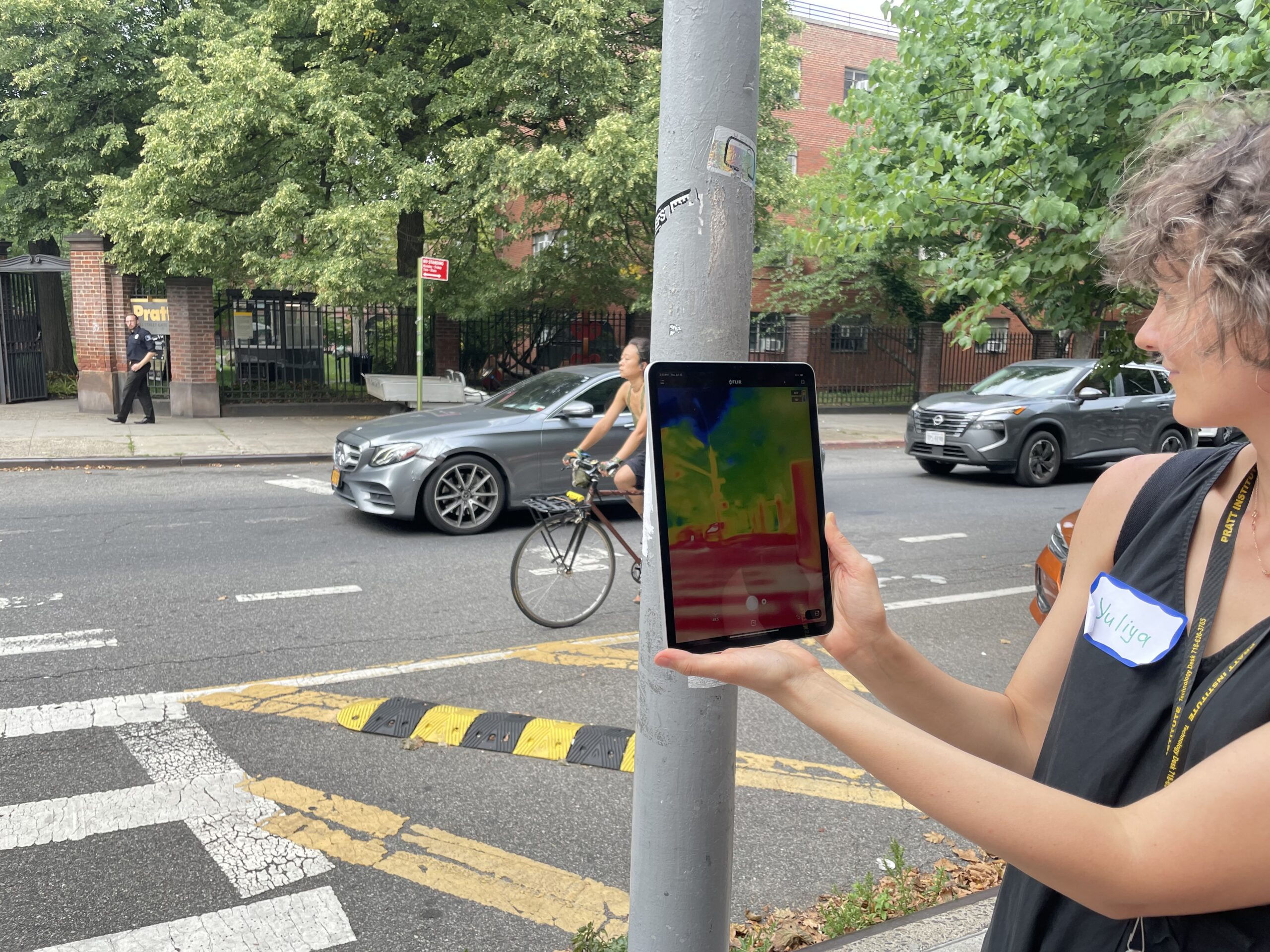 Dzuyban holds up a tablet which depicts an infrared view of the street