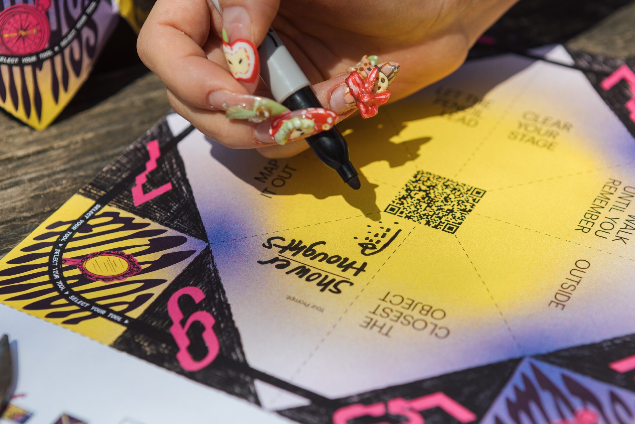 Close-up of someone writing "shower thoughts" onto a unfolded paper fortune teller
