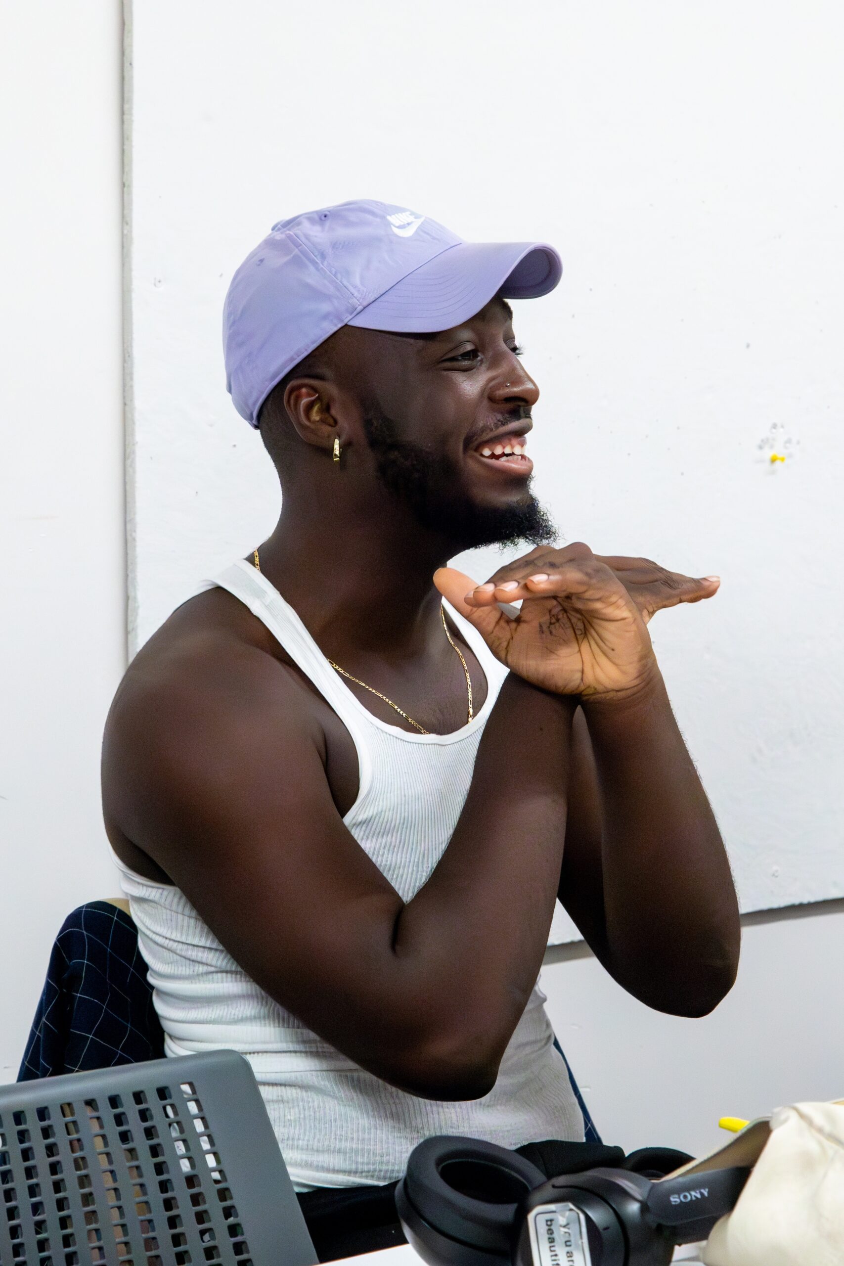 Close up of a student smiling in the classroom, gesturing with his hands