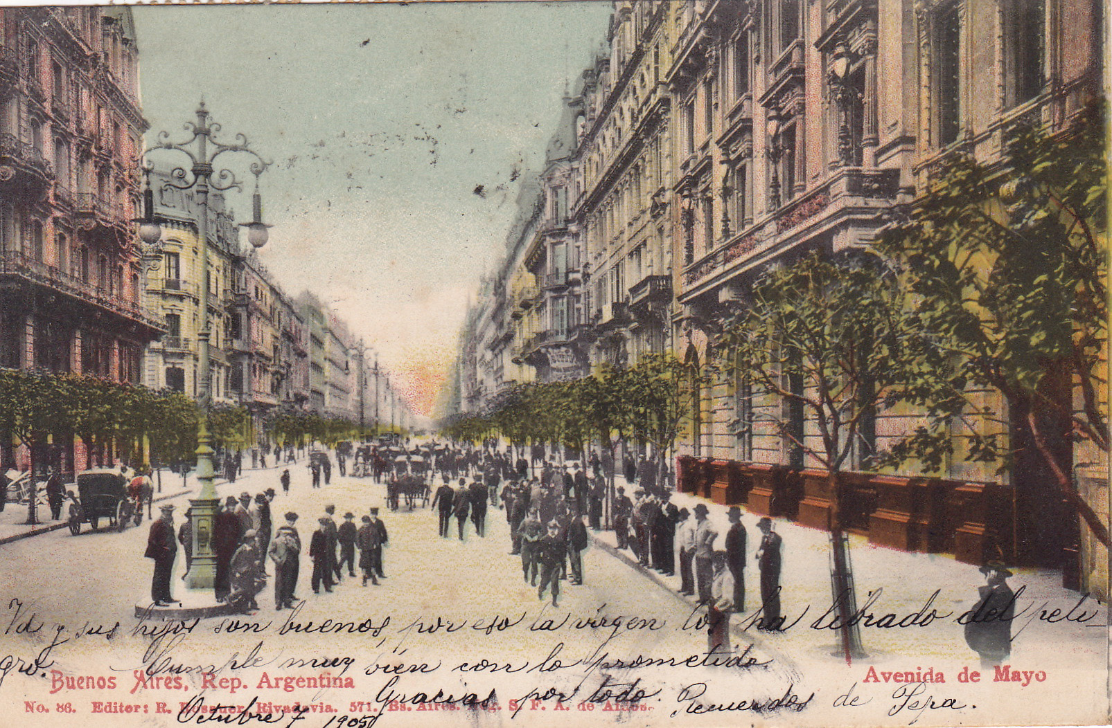 Tinted vintage postcard depicting Avenida de Mayo in Buenos Aires, Argentina. The wide avenue is flanked by ornate multi-story buildings with balconies and trees. People in early 20th-century attire walk or stand on the sidewalk and street. Handwritten text in Spanish is visible across the image.