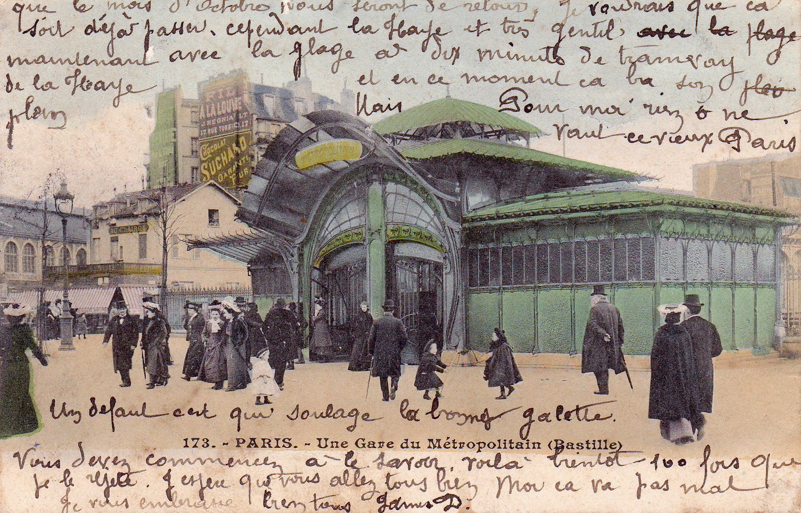 Early 20th-century postcard of a Paris Métro station (Bastille), titled “Une Gare du Métropolitain.” The green Art Nouveau entrance is surrounded by pedestrians in formal Edwardian attire. French handwriting overlays the sky area and the bottom edge of the card.