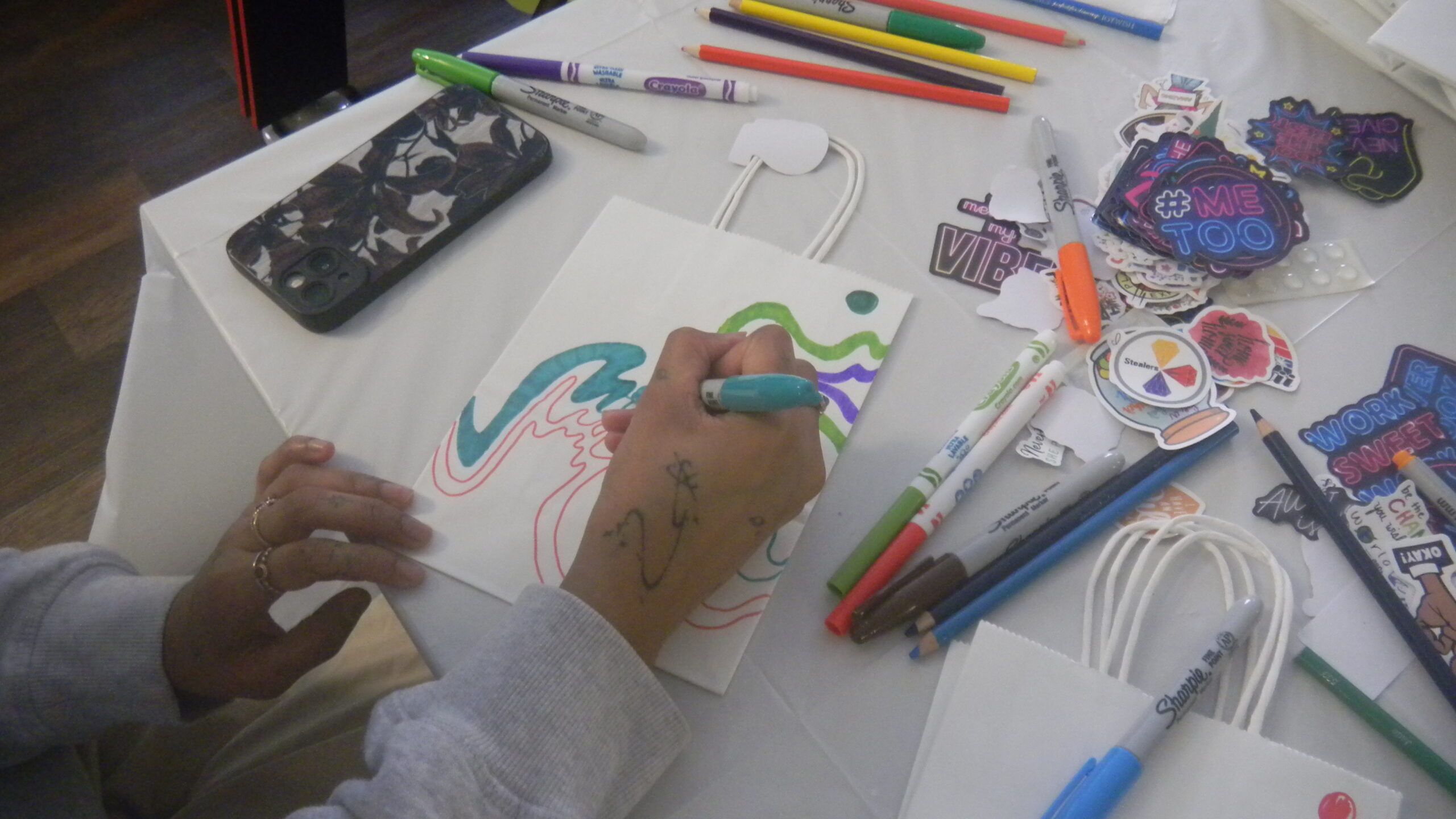 A student drawing colorful designs on the care packages (photo by Prisha Goldy Pakania, BFA Communications Design (Graphic Design) ’26)
